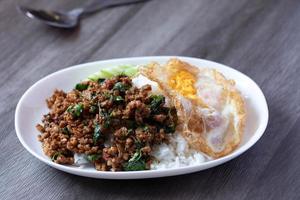 Stir-fried basil with minced pork and fried egg, popular Thai food. photo