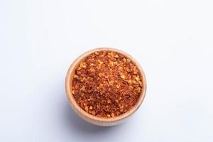 dried chili peppers in a wooden cup on a white background photo