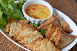 Triangular fried tofu eating with spicy dipping sauce, sweet and spicy photo