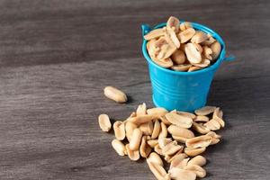 Baked peanuts in a bucket on a wooden background photo