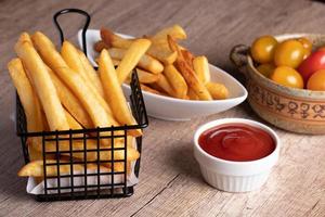 French fries in a black basket with tomato sauce photo