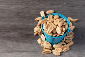 Baked peanuts in a bucket on a wooden background photo