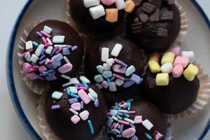 Chocolate balls sprinkled with colored sugar, cute cakes. photo