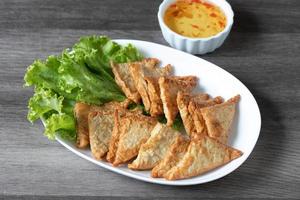 Triangular fried tofu eating with spicy dipping sauce, sweet and spicy photo