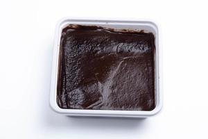 Chocolate cake is shown in a square box.On a white background. photo