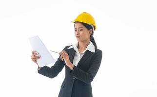 Young engineer woman wear black suit and yellow safety helmet holding note on isolated white background. photo