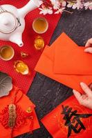 Design concept of Chinese lunar January new year - Woman holding, giving red envelopes ang pow, hong bao for lucky money, top view, flat lay, overhead above. The word 'chun' means coming spring.