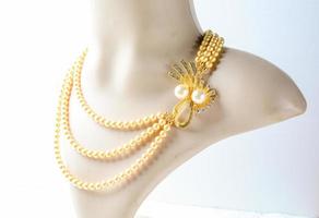 Pearl necklace on mannequin and on white background photo