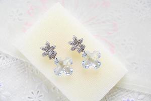 Crystal earrings on white fabric background photo