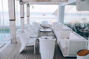 configuración de mesa y sillas de restaurante en el comedor con vista al mar foto