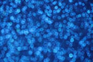 Blue sparkle blurry background with blurred dots texture photo