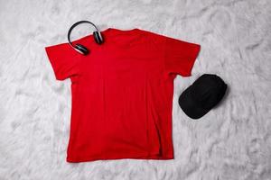 Red t-shirt mockup with man accessories on grey background. Flat lay tee template photo