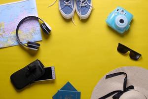 Flat lay of traveler accessories for holiday concept with copy space on yellow background photo