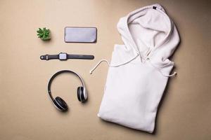 Mockup of a folded white pullover hoodie with man accessories photo
