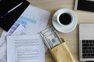 Top view Dollar bills in brown envelope on office desk. Bribery and corruption concept photo