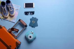 Flat lay of travel or holiday concept with copy space on blue background photo