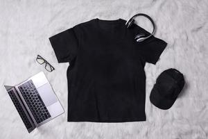 Black t-shirt mockup with man accessories on grey background. Flat lay tee template