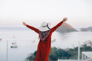 mujer de la libertad disfrutando de la vista al mar desde la azotea foto