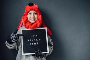 Cute boy with happy expression wearing winter clothes welcomes winter season photo