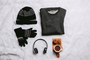 Creative flat lay of sweater, beanie, winter gloves for winter season background photo