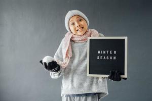 A boy wearing winter clothes welcomes winter season happily photo