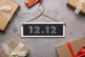 12.12 súper venta día de compras concepto plano con cajas de regalo aisladas sobre fondo de cemento foto