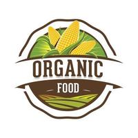 una imagen del logotipo del emblema que representa un montón de maíz fresco y un campo agrícola como icono para una etiqueta de producto orgánico saludable vector