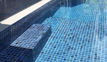 clear water in the swimming pool is covered with mosaics photo