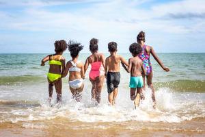 Kids playing running on sand at the beach photo