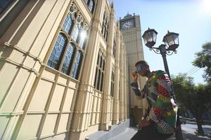 hombre afroamericano divirtiéndose caminando en el centro de la ciudad - joven feliz disfrutando del tiempo una puesta de sol al aire libre - estilo de vida de generación milenaria y concepto de actitud positiva de la gente foto