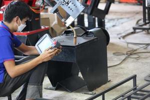Industrial engineer or worker wearing a helmet while standing in a heavy industrial factory. The Maintenance looking of working at industrial machinery and check security system setup in factory. photo