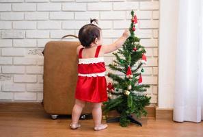 Little baby girl in red costume on Christmas day. photo