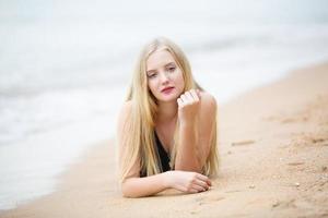 Beautiful blonde woman on black bikini enjoy summertime on the beach. photo