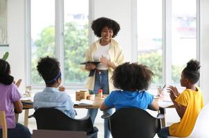 los niños afroamericanos estudian con amigos en clase. foto