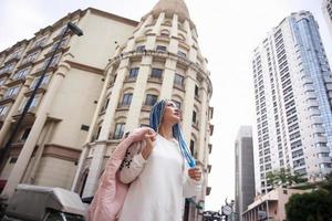 retrato de una joven de cabello azul, adolescente de pie en la calle como vida urbana. foto