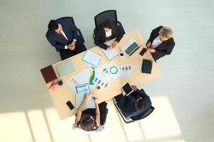 Top view on a group of businessman and businesswoman having a meeting and making a business commitment. photo