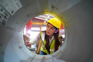 Female worker Foreman or worker work at factory site check up machine or products in site. Engineer or Technician checking Material or Machine on Plant. Industrial and Factory. photo