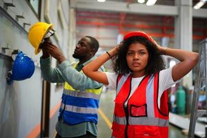 el capataz de los trabajadores de la industria o el trabajo de los trabajadores en el sitio de la fábrica revisan la máquina o los productos en el sitio. ingeniero o técnico revisando material o máquina en planta. industrial y fábrica. foto