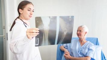 una doctora y un paciente anciano se revisan en el hospital. foto