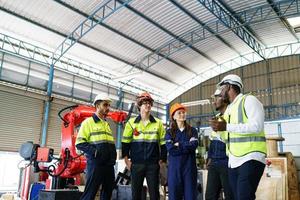 Industrial engineer or worker wearing a helmet while standing in a heavy industrial factory. The Maintenance looking of working at industrial machinery and check security system setup in factory. photo