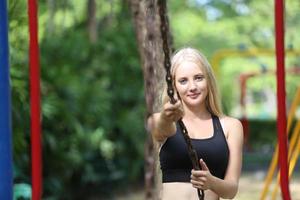 A beautiful woman wearing exercise clothes is playing and enjoying the nature in the garden during the day. photo