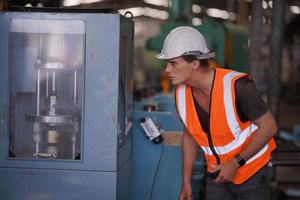 Maintenance Engineers is working in front of the automated CNC machinery repair on a maintenance checklist at the production line. photo