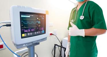 concepto médico y de salud. médico con estetoscopio y guantes en la mano y monitor de electrocardiograma con electrocardiograma de pulso en el hospital. foto