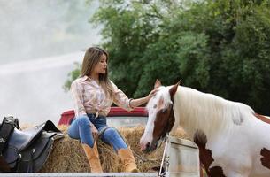 Young woman with her horse in evening sunset light. Outdoor photography with fashion model girl. Lifestyle mood photo