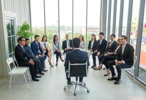 grupo de personas que escuchan a profesionales de negocios experimentados que los ayudan a elaborar una nueva estrategia corporativa.