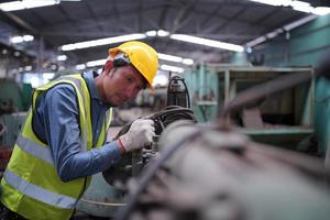 los ingenieros de mantenimiento están trabajando frente a la reparación automatizada de maquinaria cnc en una lista de verificación de mantenimiento en la línea de producción. foto