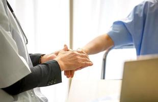 primer médico sosteniendo la mano femenina para darle esperanza. foto