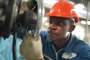 Maintenance Engineers is working in front of the automated CNC machinery repair on a maintenance checklist at the production line. photo