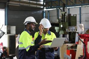 Maintenance Engineers is working in front of the automated CNC machinery repair on a maintenance checklist at the production line. photo