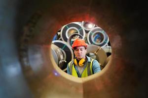 el capataz de los trabajadores de la industria o el trabajo de los trabajadores en el sitio de la fábrica revisan la máquina o los productos en el sitio. ingeniero o técnico revisando material o máquina en planta. industrial y fábrica. foto